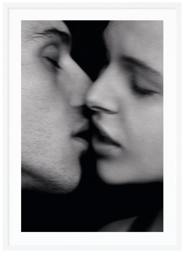 Svart-vit poster. Närbild av man och kvinna iingåendes för kyss. Vit ram.