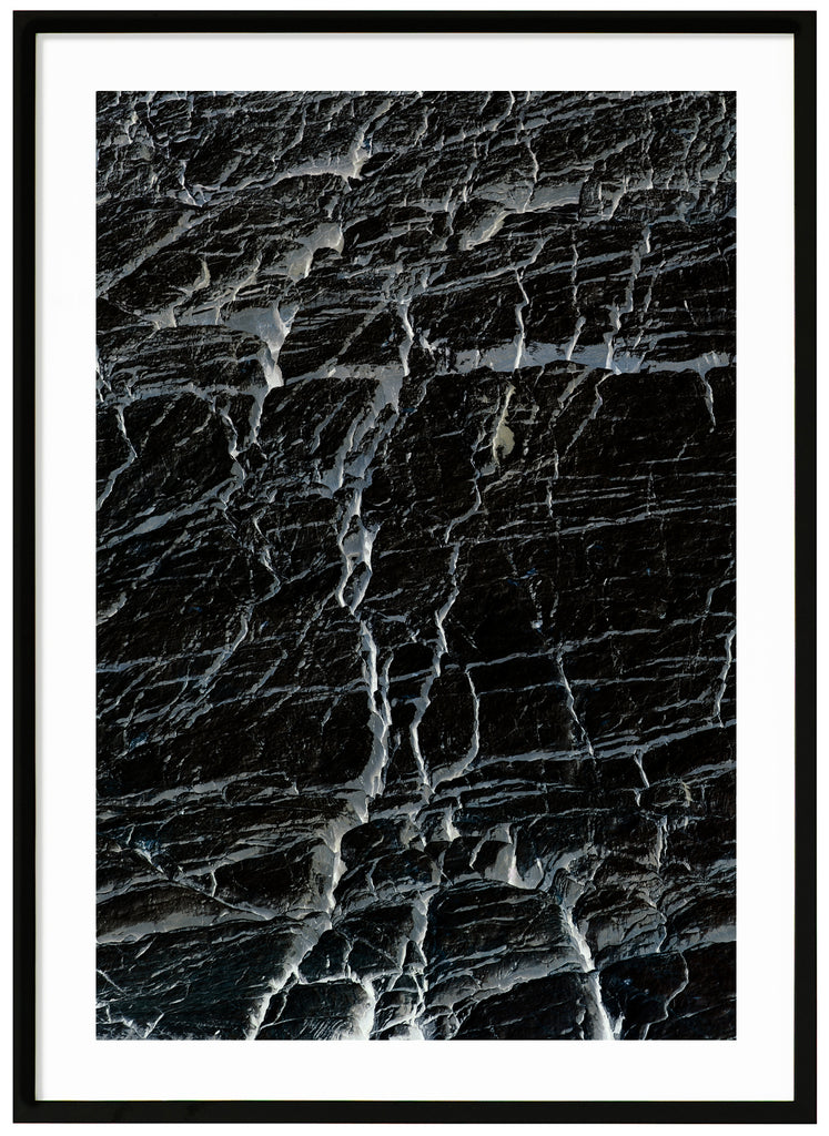 Svart-vit halvabstrakt poster med gråblå toner av sprickor. Svart ram.