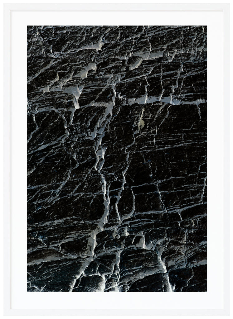 Svart-vit halvabstrakt poster med gråblå toner av sprickor. Vit ram.