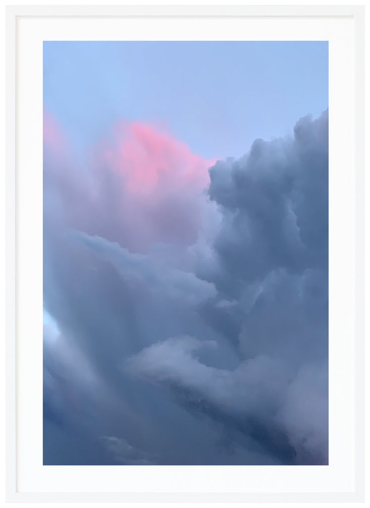 Poster av moln i blågrå toner och en ljusrosa nyans. Vit ram.