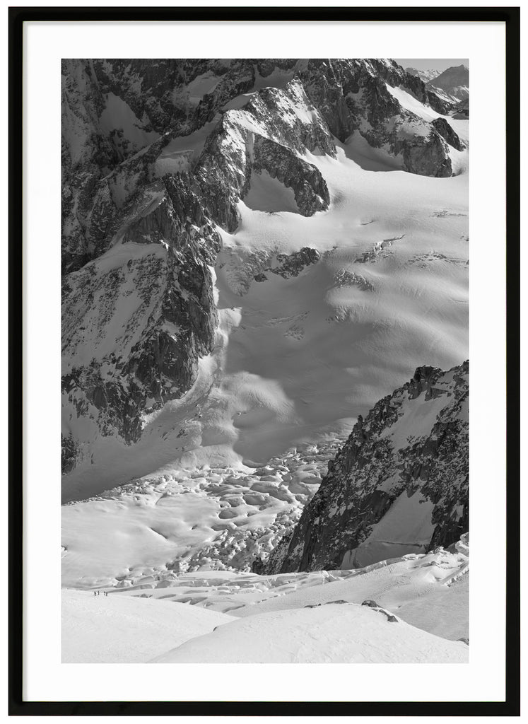 svart-vit poster av soldränkt snötäcke över bergen i alperna. Svart ram