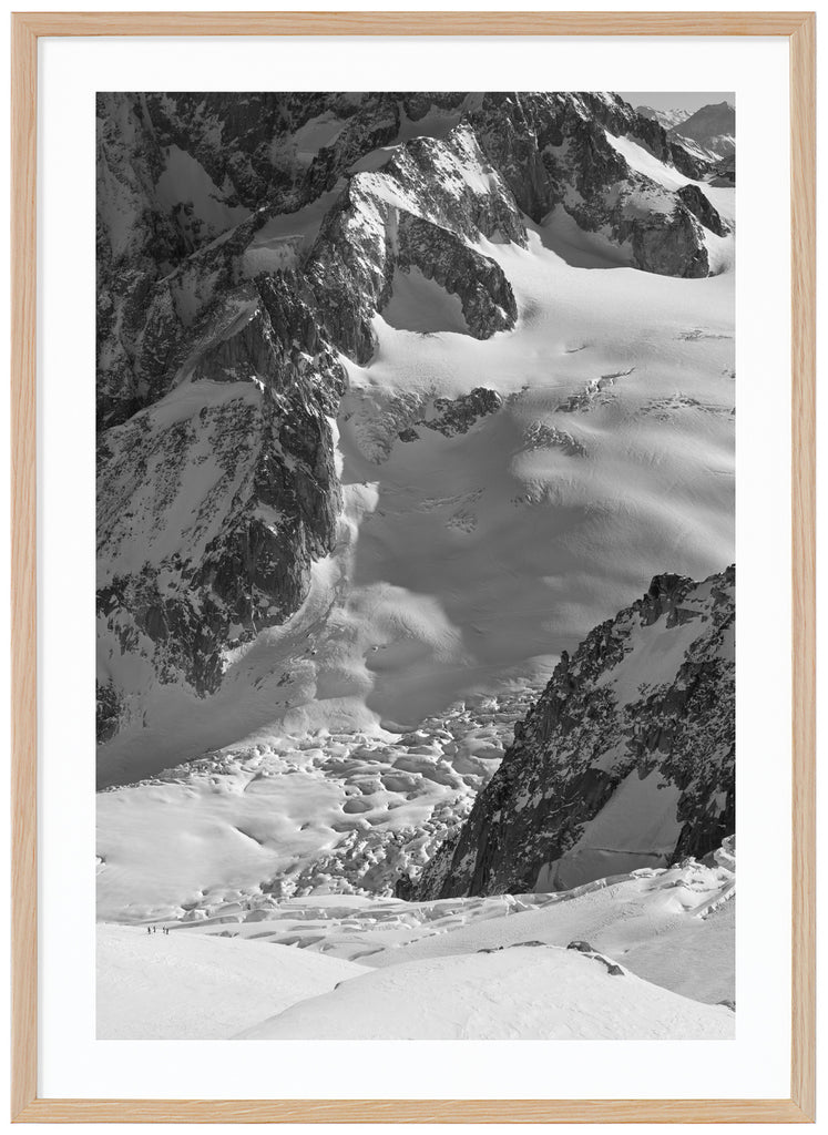 svart-vit poster av soldränkt snötäcke över bergen i alperna. Ekram
