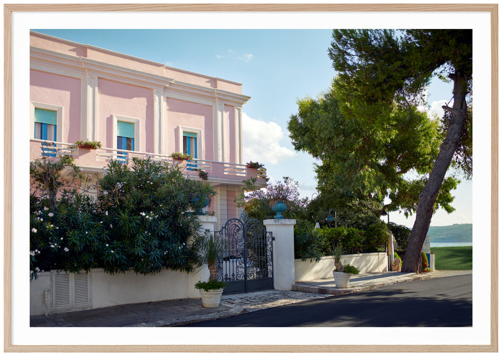 Poster av ett rosa hus med blå fönsterkarmar och turkosa luckor. Ekram.