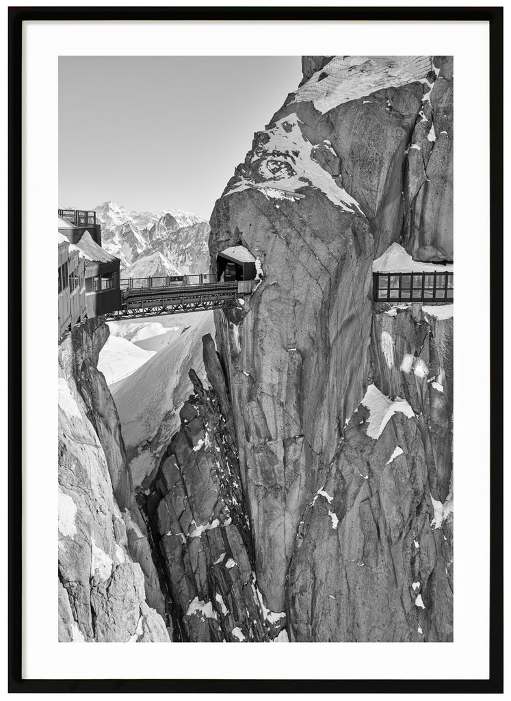 Poster av bro mellan klippväggar, svart-vitt foto. Svart träram.