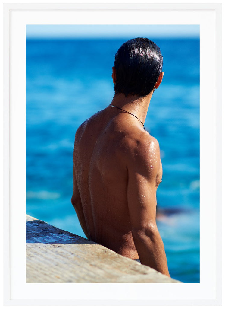 Poster av en mans nakna ryggtavla vid havet. Stående format. Vit ram.