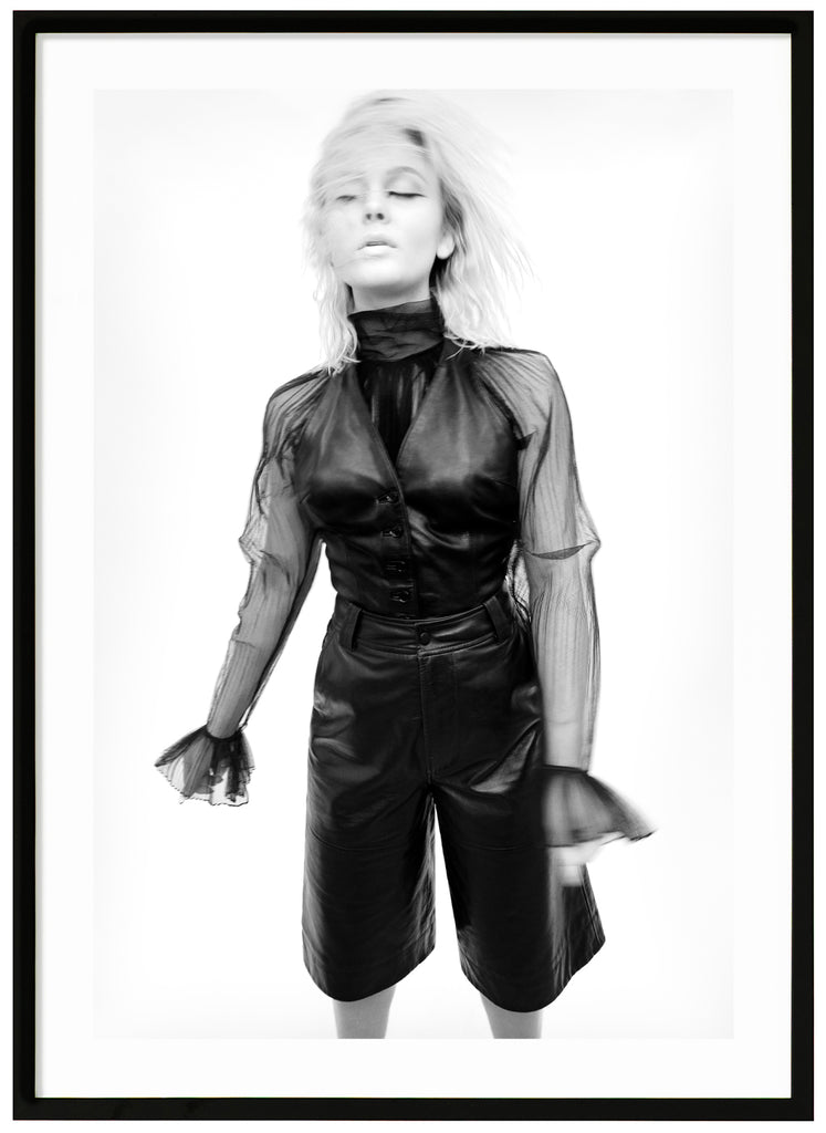 Svart-vit poster av Zara Larsson i svart klädsel. Vit bakgrund och håret i ansiktet. Svart ram.