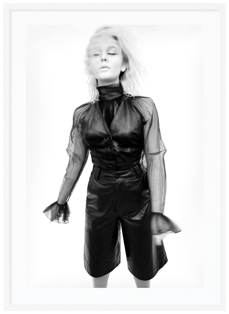 Svart-vit poster av Zara Larsson i svart klädsel. Vit bakgrund och håret i ansiktet. Vit ram.