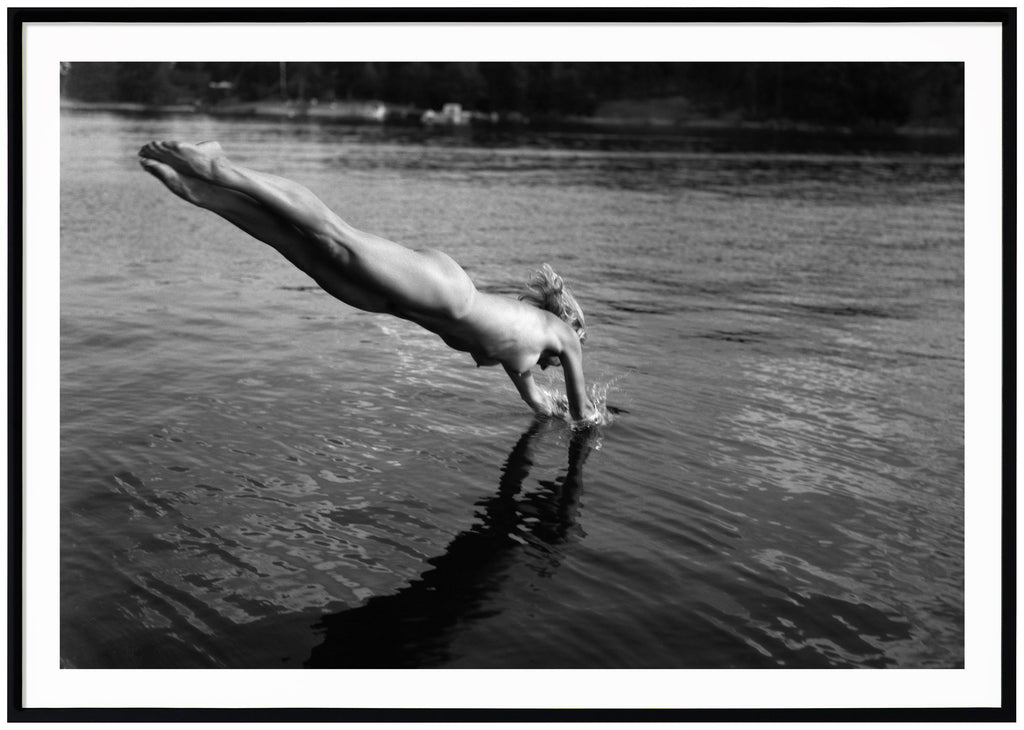Poster av analogt foto. Naken kvinna som dyker ner i vattnet. Svart ram.