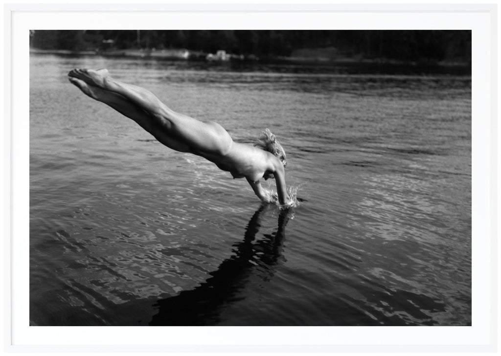 Poster av analogt foto. Naken kvinna som dyker ner i vattnet. Vit ram.