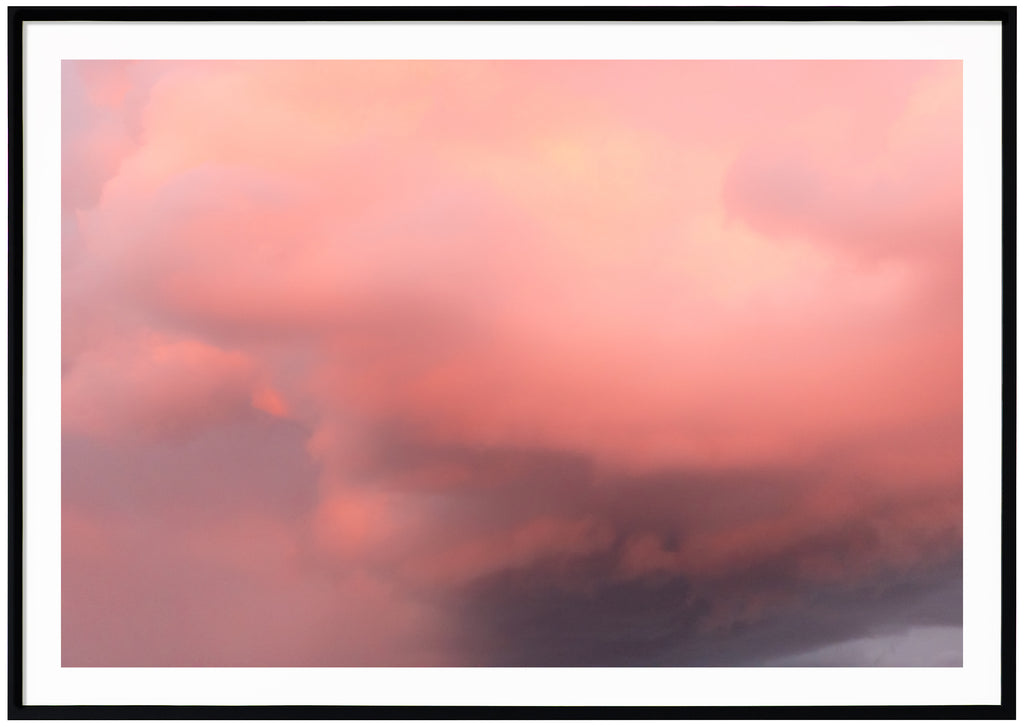 Poster av rosa och lila moln. Liggande format. Svart ram. 