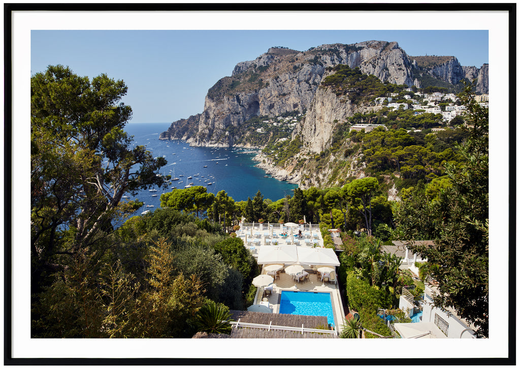 Vy över simbassäng, hav och berg på ön Capri i Italien. Svart ram