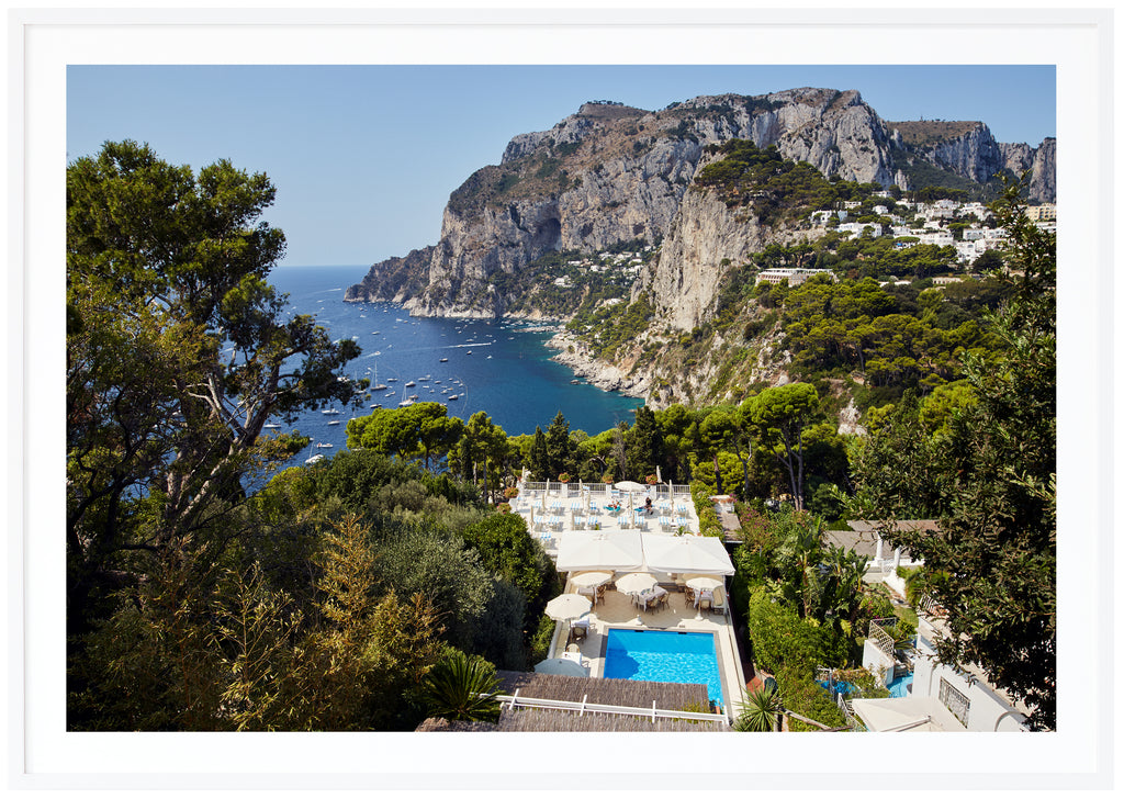 Vy över simbassäng, hav och berg på ön Capri i Italien. Vit ram