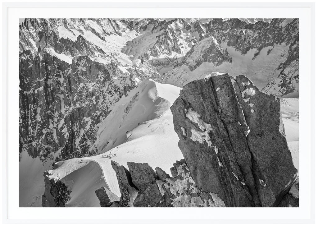 Svart-vitt fotografi av klippor och alper i Frankrike. Vit ram