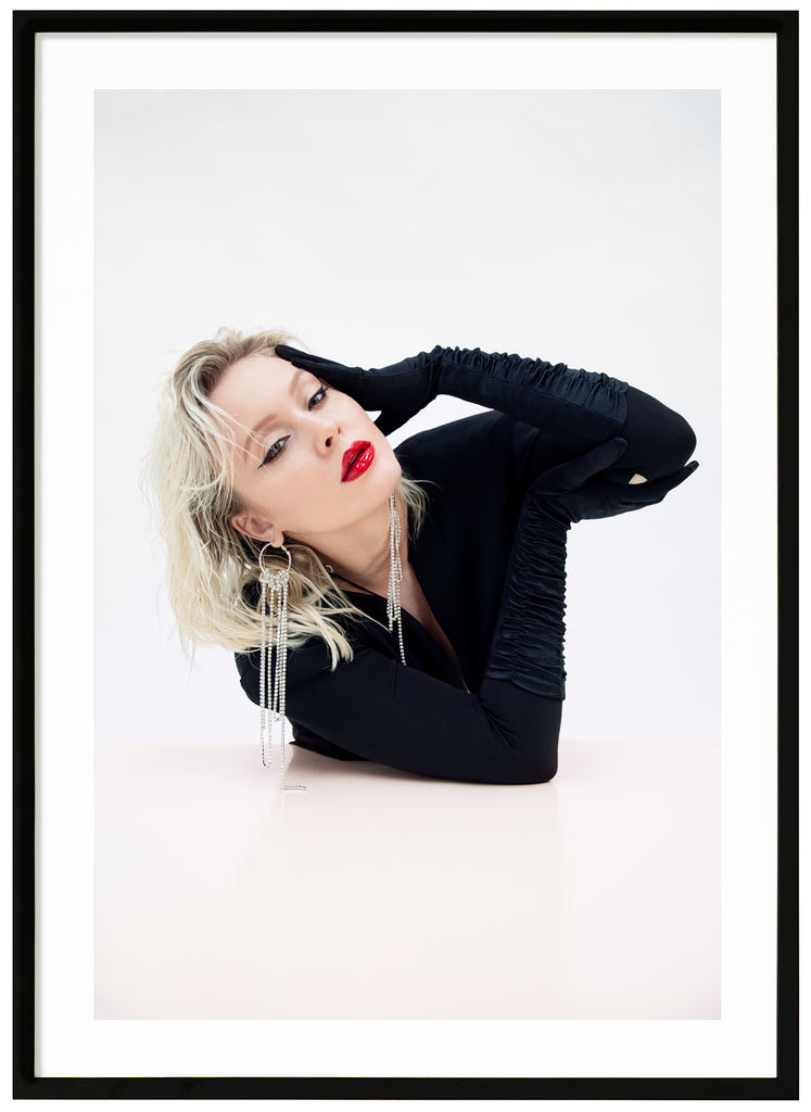 Poster av Zara Larsson. Klädd i svart med rött läppstift mot vit bakgrund. Svart ram.