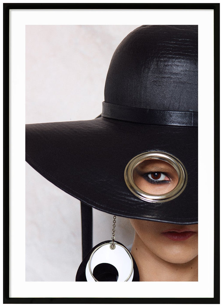 Poster av kvinna med stor svart hatt. Vit bakgrund. Svart ram.