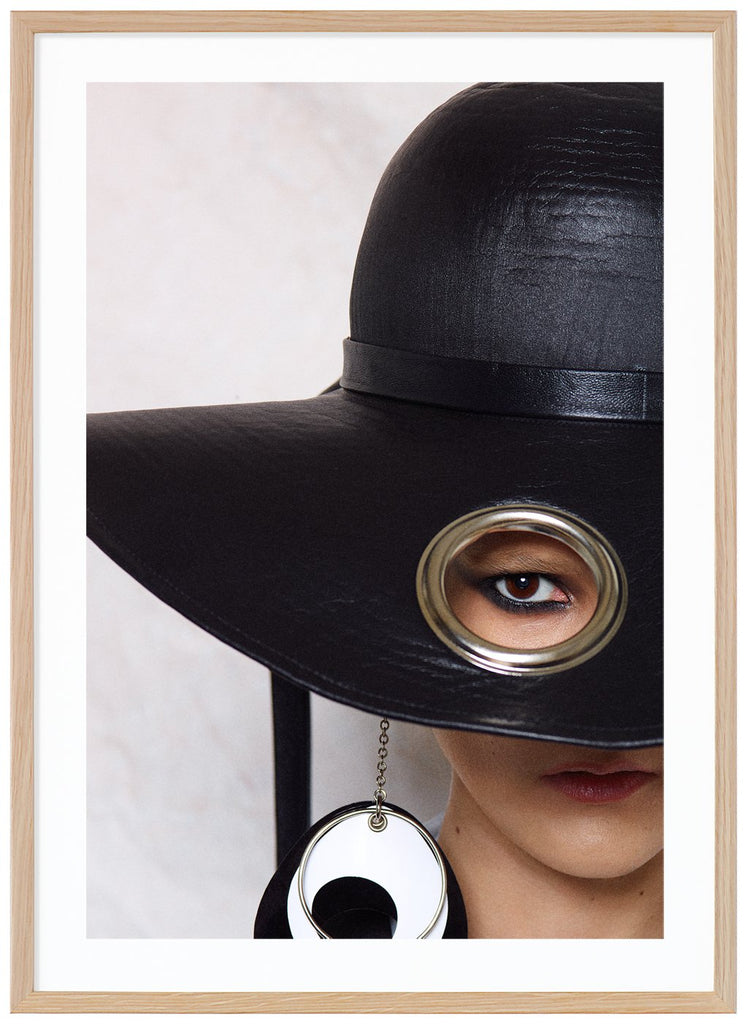 Poster av kvinna med stor svart hatt. Vit bakgrund. Ekram.