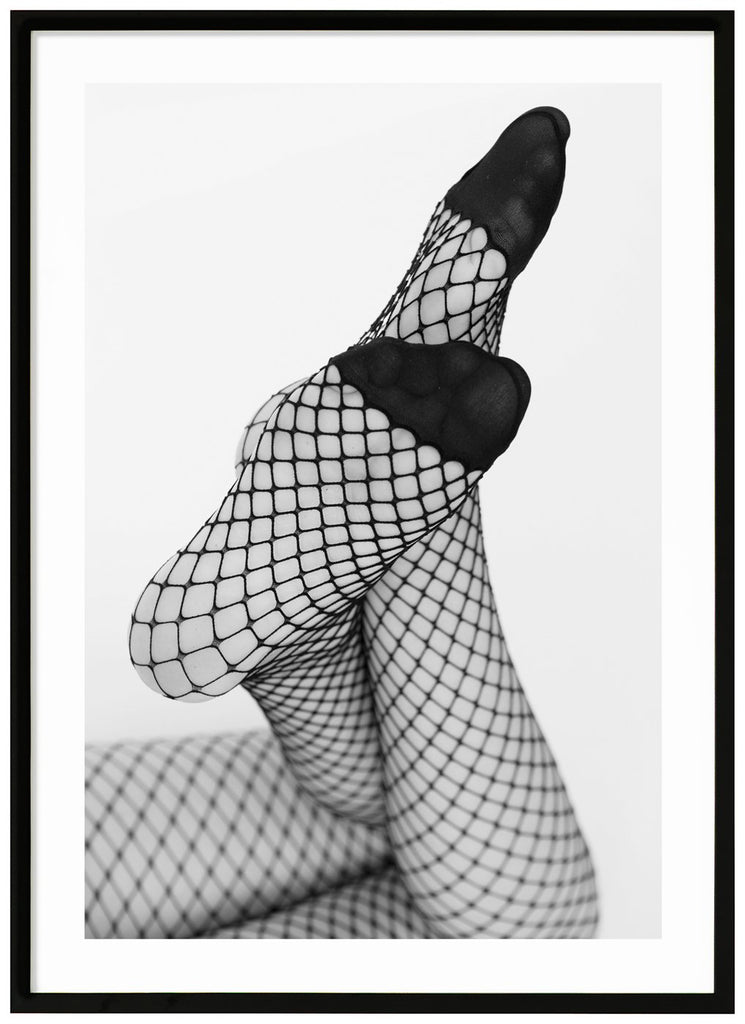 Svart-vitt fotografi av en kvinnas ben med fötterna vinklar mot kameran, hon bär nät strumpbyxor. Svart ram. 