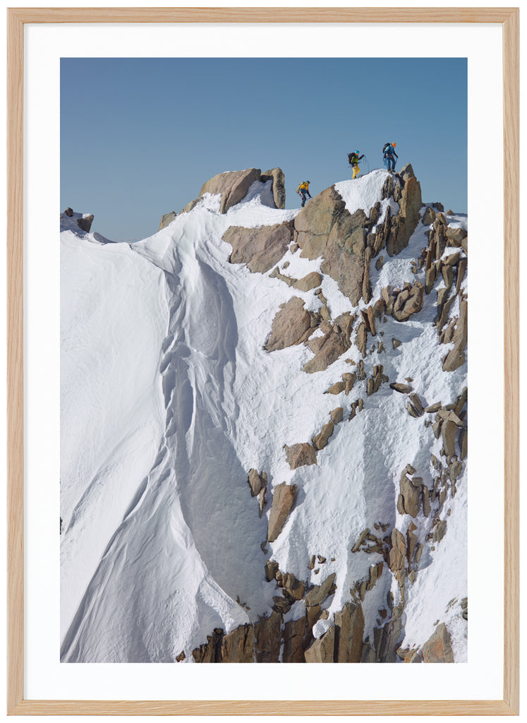 Färgfotografi av tre bergsklättrare på toppen av branta klippor. Ekram. 