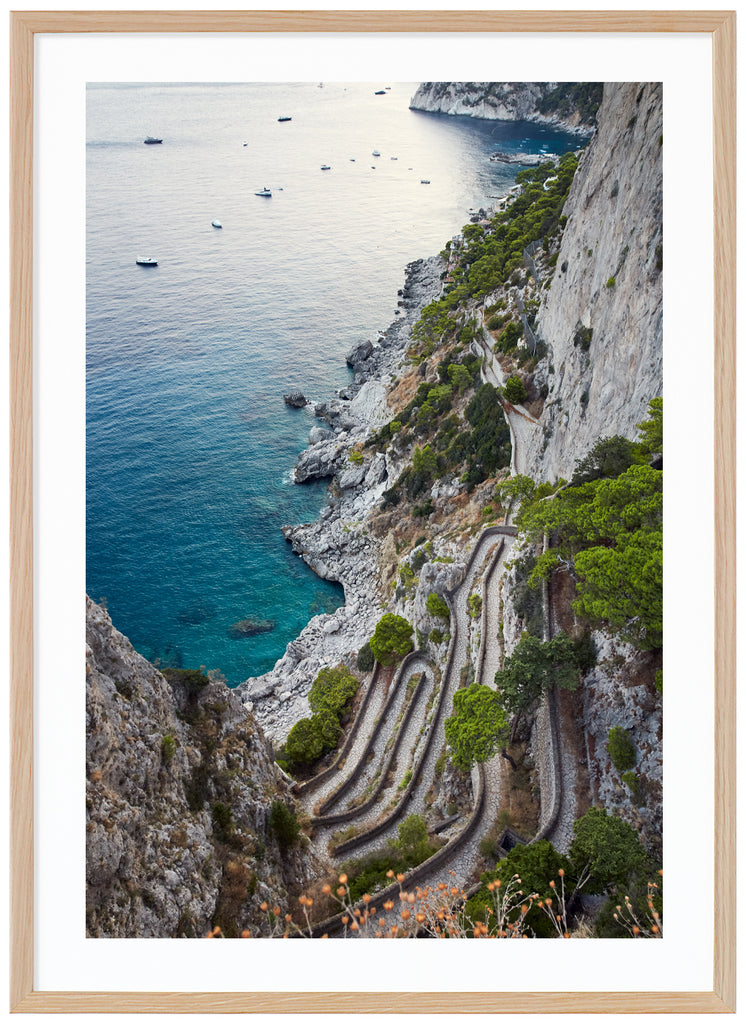 Fotografi i färg av utsikt över ett promenadstråk i sten på Italienska ön Capri. Verticale.  Ekram. 