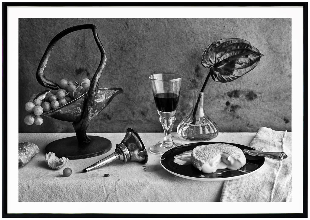 Svart-vit poster av dukat bord med ost, vin och vindruvor. Kanvas-bakgrund. Liggande format. Svart ram.