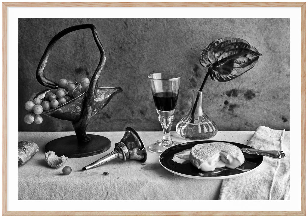 Svart-vit poster av dukat bord med ost, vin och vindruvor. Kanvas-bakgrund. Liggande format. Ekram.